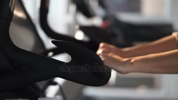 Primer plano plano de las manos de mujer sosteniendo asas de bicicleta de gimnasio de ciclismo — Vídeo de stock