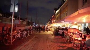 Copenhagen, Danimarka - Nisan 2017: İnsanların, barlar ve restoranlar ile Nyhavn Simgesel Yapı alanı, yürüyüş turist gece video