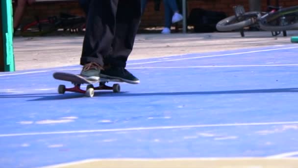 Um homem jogando skate truque no chão de concreto em câmera lenta — Vídeo de Stock