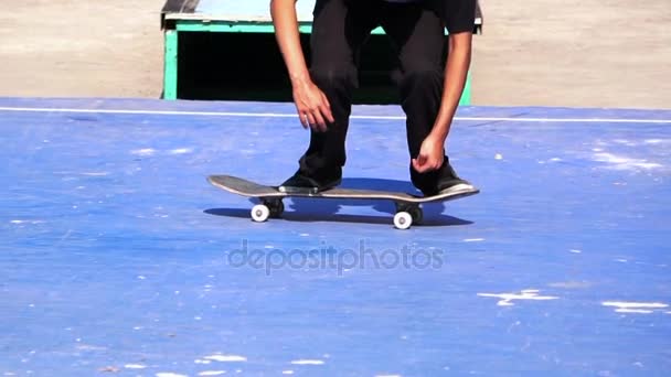 Un uomo che gioca a skateboard trucco sul pavimento di cemento al rallentatore — Video Stock