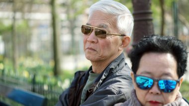 Kızgın güneş gözlüğü karısı görünen Asya kıdemli adam wh