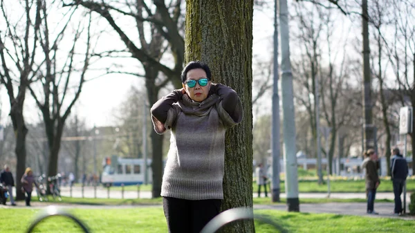 Asian senior woman travel in europe taking portrait in park — Stock Photo, Image