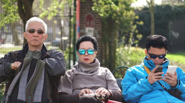 Aziatische familie reizen samen. Zoon is verbinding met het internet op zoek fo — Stockfoto