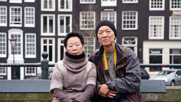 Asian senior couple travel to Amsterdam together. Taking photo w — Stock Photo, Image