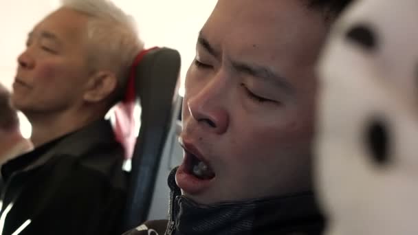 Ázsiai férfi néz ki, hogy a fáradt, és próbálja aludni repülés során a légi plane — Stock videók