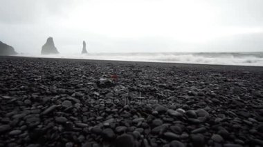 4 k siyah kumlu lav beach Vik, İzlanda. Düşük açılı, tilt Simgesel Yapı sahil yakınında bazalt deniz yığınları yukarı
