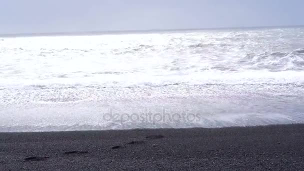 4 k siyah kumlu lav beach Vik, İzlanda. Düşük açılı, tilt Simgesel Yapı sahil yakınında bazalt deniz yığınları yukarı — Stok video