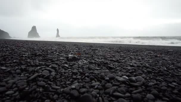 4 k siyah kumlu lav beach Vik, İzlanda. Düşük açılı, tilt Simgesel Yapı sahil yakınında bazalt deniz yığınları yukarı — Stok video