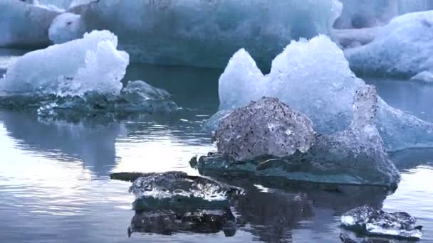 Pequeños y grandes trozos de iceberg flotando en la laguna glaciar de Jokulsarlon. Calentamiento global derretimiento problema de hielo — Vídeos de Stock