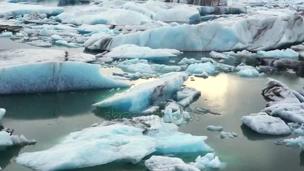 Pequenos e grandes pedaços de iceberg flutuando na lagoa do glaciar Jokulsarlon. Problema do aquecimento global derretendo gelo — Vídeo de Stock