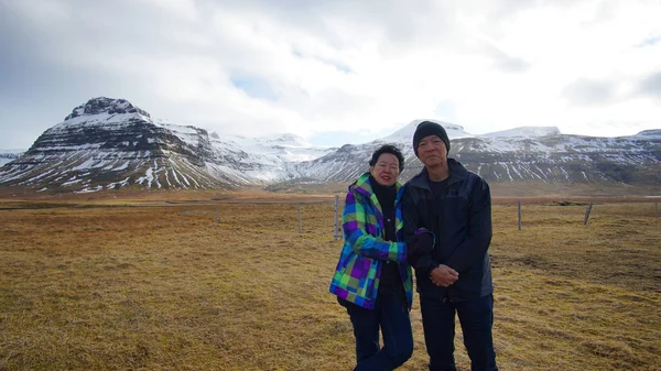 Asian senior couple enjoy anniversary trip in Europe. Iceland volcanic landscape mountain with snow amazing view — Stock Photo, Image