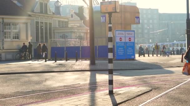 Amsterdam, Nizozemsko - duben 2017: Krásné ranní slunce a lidé na hlavní nádraží, čekání na tramvajovou dopravu. Zpomalený pohyb 120fps — Stock video