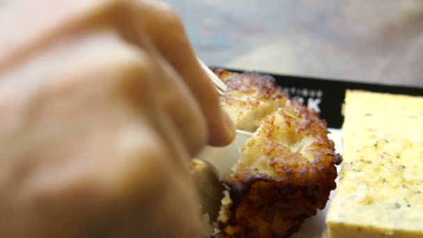 Schneiden von frisch gebackenem Fischkuchen von europäischem Imbiss mit der Hand — Stockvideo