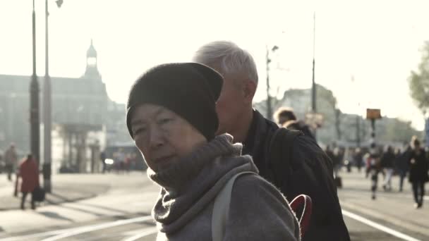 Pareja asiática mayor esperando tranvía en Amsterdam. Viajar por el mundo después de la jubilación por sí mismos — Vídeos de Stock