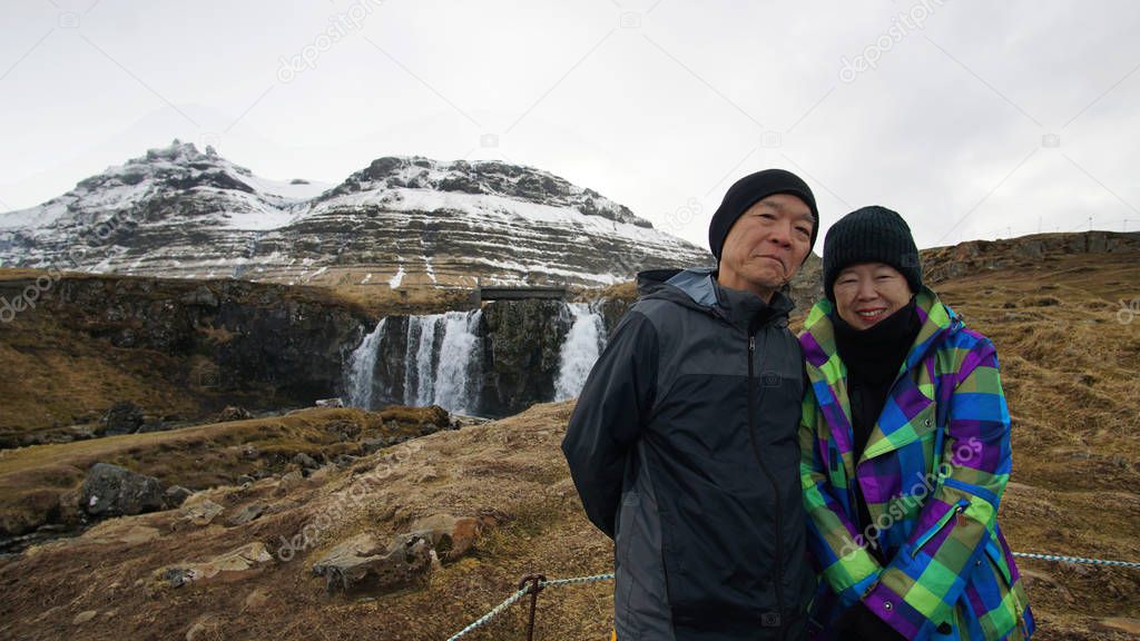 Asian retired senior travel around the world to Iceland. Happy together at Kirkjufell landmark mountain