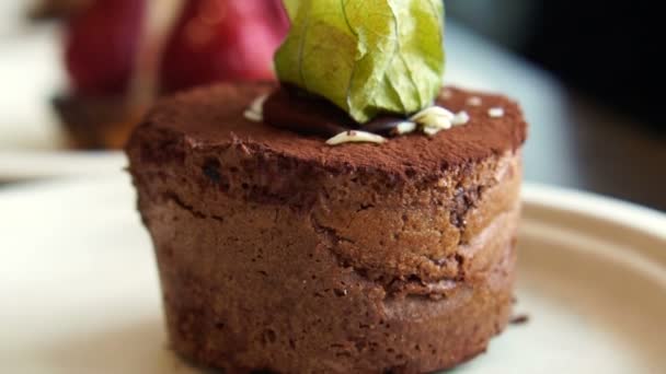 Close-up van textuur lava donker chocolate cake met topping van cape gooseberry dienen in bakkerij — Stockvideo