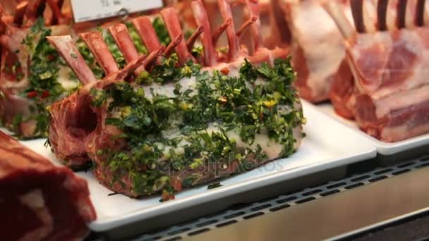Estante crudo de cordero se venden en el mercado. Carne cruda y hierbas marinadas en la carnicería — Vídeos de Stock
