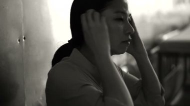 Asyalı kadın hastanede tek başına oturmak. Merak ve endişe düşünme kötü haber 4k dan