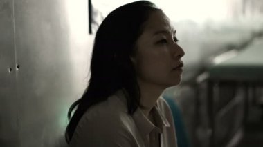 Asyalı kadın hastanede tek başına oturmak. Merak ve endişe düşünme kötü haber 4k dan
