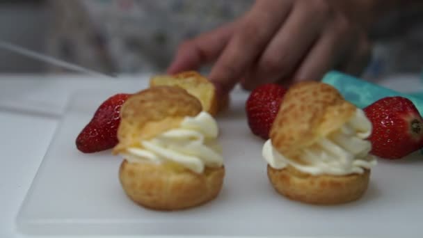 Puffs de creme de morango, creme de choux, creme de enchimento de mão dentro de pastelaria assada — Vídeo de Stock