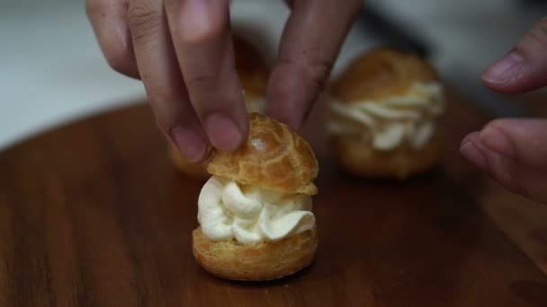 Ręka co napełniania chuox cream puff i organizowanie dla sprzedaży w sklepie piekarni — Wideo stockowe