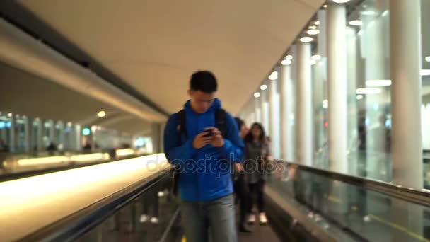 Tokio, Japón - Diciembre 2017: Hombre mochilero asiático comprobando el uso de un teléfono inteligente en el aeropuerto — Vídeos de Stock