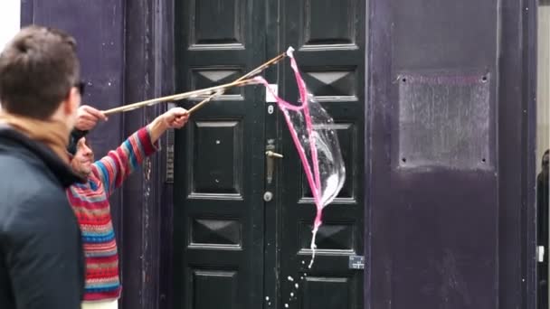 Copenhague, Dinamarca: abril de 2017 - Artista callejero que crea una gran burbuja de jabón en el centro de la ciudad para entretener a los peatones — Vídeo de stock