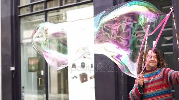 Copenhague, Dinamarca: Abril 2017 - Artista de rua criando uma grande bolha de sabão no centro da cidade para entreter pedestres — Vídeo de Stock