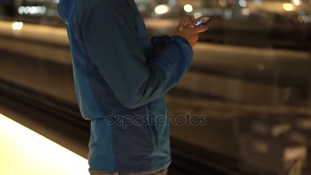 Asiático mochileiro homem verificando usando telefone inteligente no aeroporto após a aterrissagem à noite — Vídeo de Stock