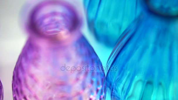 Colorful glass bottles and vases. Close up abstract vivid rainbow color material — Stock Video