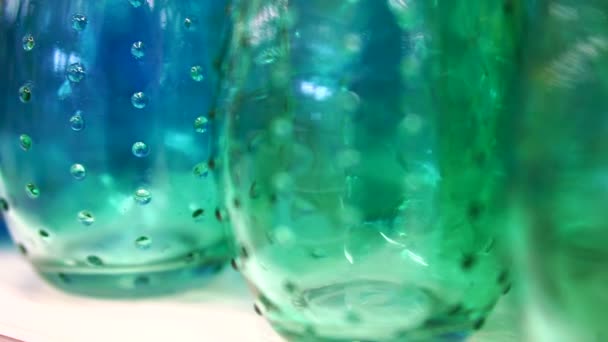 Bouteilles et vases en verre coloré. Gros plan abstrait vif matériau couleur arc-en-ciel — Video