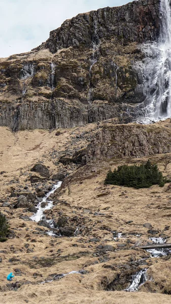 Escala hombre trekking con majestuoso tamaño de montaña cascada. ¿Cómo? —  Fotos de Stock