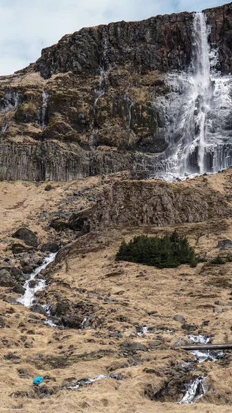 Escala hombre trekking con majestuoso tamaño de montaña cascada. ¿Cómo? —  Fotos de Stock
