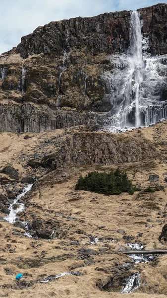 Escala hombre trekking con majestuoso tamaño de montaña cascada. ¿Cómo? —  Fotos de Stock