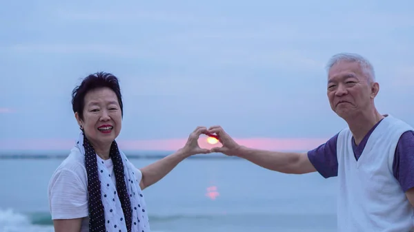 Asian senior couple together at sunrise beach. New year, new chapter concept — Stock Photo, Image