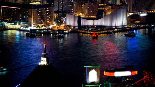 Hong Kong Victoria harbour and its iconic red ancient junk sail zoom shot from the Peak at night — Stock Photo, Image