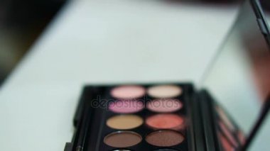 Asyalı kadın yüz fırça yapmak üzerinde yapıyor makyaj renk paleti üzerinden vurdu