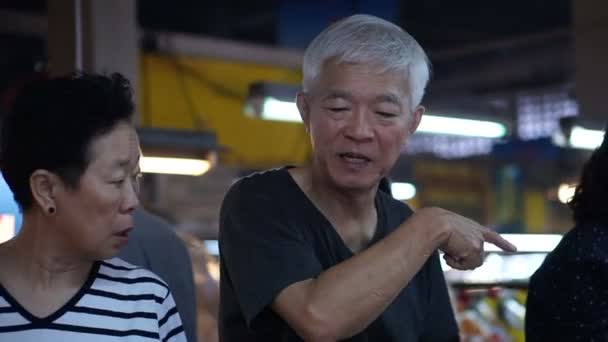 Aziatische senior paar winkelen voor voedsel op lokale markt van Zuidoost-Azië — Stockvideo