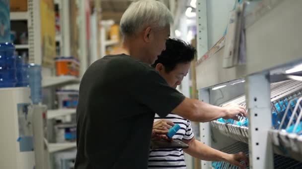 Azjatki pary starszy wybranie wodociągu w budowę domu mall. Za pomocą klawiatury do wyszukiwania informacji w Internecie — Wideo stockowe