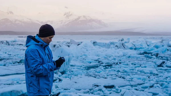 Asiatische Mann mit Kamera, die jokulsarlon, Gletscherlagune Island. Weltreiseziel — Stockfoto