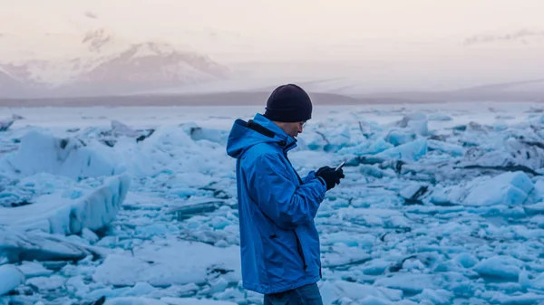 Ασιατικό άτομο χρησιμοποιώντας έξυπνο τηλέφωνο στο Γιόκουλσάρλον, παγετώνας λιμνοθάλασσα Ισλανδία. Παγκόσμια ταξιδιωτικός προορισμός — Φωτογραφία Αρχείου