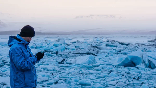 Homem asiático usando telefone inteligente no jokulsarlon, lagoa Glacier Islândia. Destino de viagem mundial — Fotografia de Stock