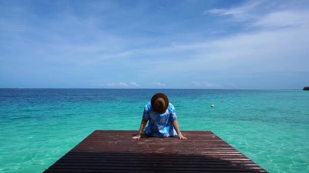 Mulher de volta relaxante olhando para turquesa paraíso ilha oceano no convés de madeira — Vídeo de Stock