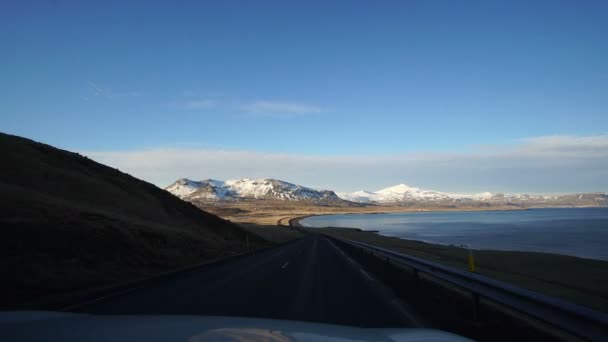 आइसलैंड के परिदृश्य को देखने के लिए सड़क यात्रा दृश्य। बर्फ पर्वत पृष्ठभूमि के साथ आइसलैंडिक महासागर पर सुंदर खाड़ी — स्टॉक वीडियो