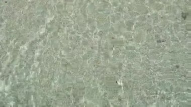 Üstten Görünüm berrak okyanus dalgaları. Ağır çekimde yumuşak beyaz kum plaj üzerine sıçramasına