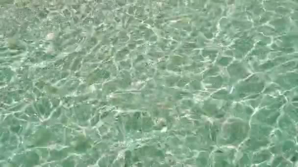 Bovenaanzicht van kristalheldere oceaan golven. Spatten over witte zachte zand strand in slow motion — Stockvideo