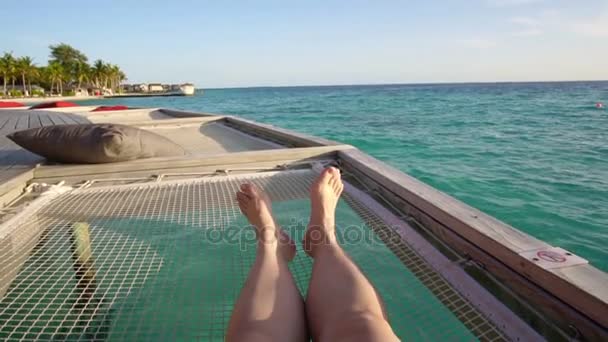 Bare feet on over ocean bed net at beautiful tropical paradise Maldives sea — Stock Video