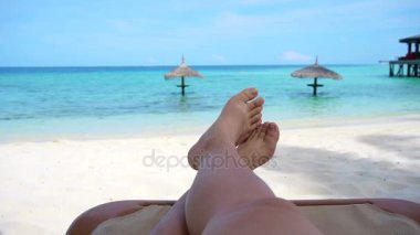 Tropikal okyanus cennete turist bacakları çıplak ayak altın kum plaj bankta oturan işaret