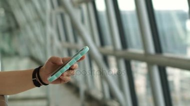 Pencerenin havaalanında uçak arka planda akıllı telefon kullanan kadın