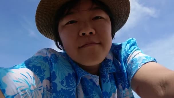Азиатские туристы идут жить на камеру размахивая и бегая по пляжу отдыха океана — стоковое видео